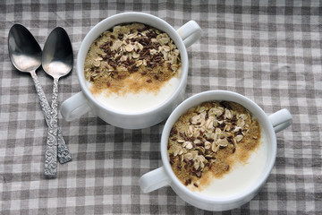 Two bowls with white yogurt, bran and seeds. Healthy breakfast. Diet food.