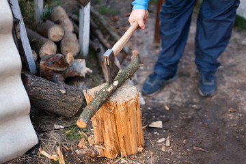 Obraz premium Man chopping wood in the backyard. Lumberjack cuts logs