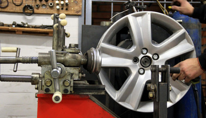 Mechanic Repair Alloy Vehicle Rim On A Balancing Machine
