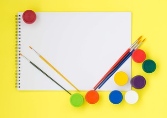 Back to school, summertime, creativity, education concept. Supplies - scissors, pencils, colored paper, paints, brushes and a notebook, an alarm clock on a colorful, flatlay. Mock up