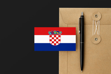 Croatia flag on craft envelope letter and black pen background. National invitation concept....