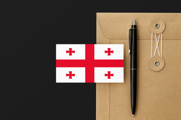 Georgia flag on craft envelope letter and black pen background. National invitation concept. Invitation for education theme.