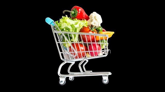 Alpha channel, 32 bit. Shopping cart moving fast from side to side and quickly filling with fruits, vegetables. Mountain of fresh vegetables, fruits, overcrowded trolley. Ability to use any background