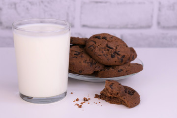 
Glass of milk and chocolate chip cookies on a white background. 