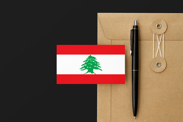 Lebanon flag on craft envelope letter and black pen background. National invitation concept. Invitation for education theme.