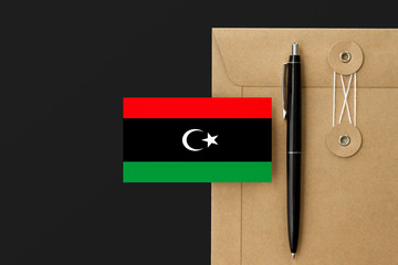 Libya flag on craft envelope letter and black pen background. National invitation concept....