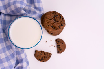 Glass of milk and chocolate chip cookies on a white background. Copy space. Flat lay.
