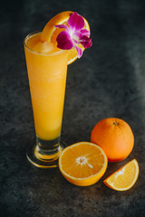 Glasses of fresh orange juice on dark background