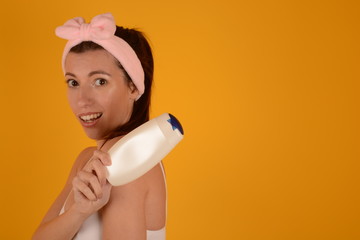 woman holds shampoo in hand