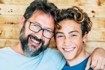Cheerful people portrait with father and son hug and laughing a lot together having fun and looking...