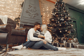 Obraz premium Lady in a white sweater. Family sitting on a floor. Couple near christmas tree.