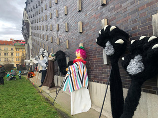giant puppets leaning against the side of a church