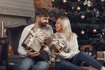 Lady in a white sweater. Family sitting on a floor. Couple near christmas tree.