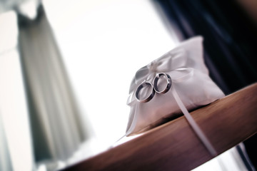 Wedding rings on the lace pillow with reflection 