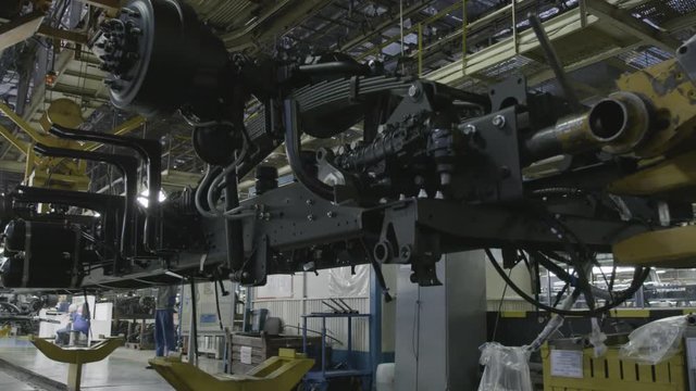 Production process of heavy mining trucks at the factory. Scene. Dump truck transmissionon the Industrial conveyor in the workshop of an automobile plant.