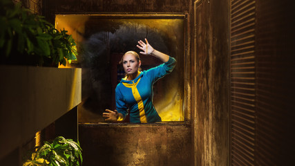 Survival woman looking at the window in apocalyptic shelter