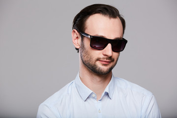 Elegant young handsome man in sunglasses. Studio fashion portrait