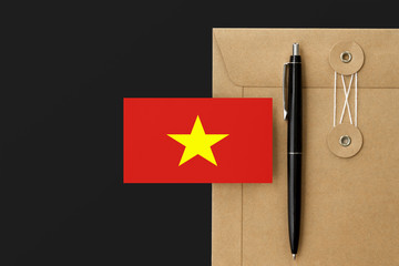 Vietnam flag on craft envelope letter and black pen background. National invitation concept. Invitation for education theme.