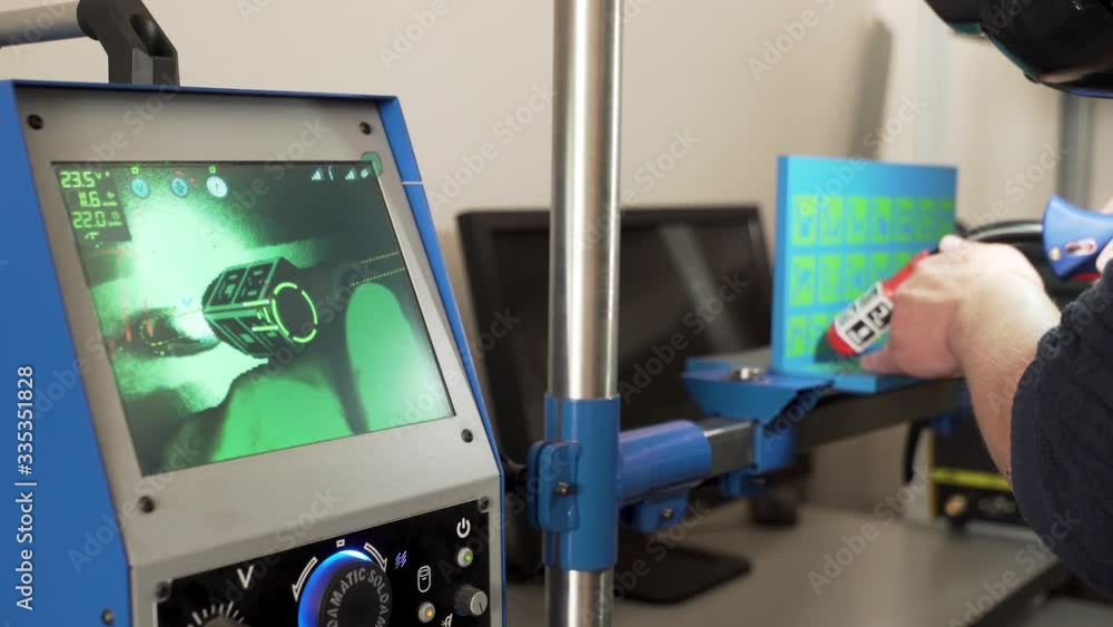 Poster close up of an engineer using modern welding equipment and a computer for welding process at the fac