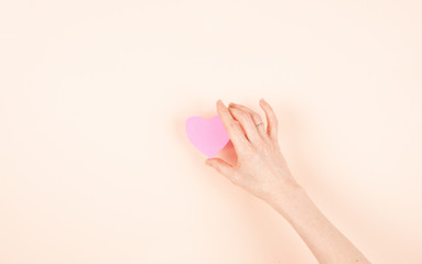 pink heart in a woman's hand, protection of love, give love, share love, give health, help