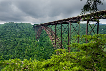 This is the steel arch New River Gorge Bridge in Fayette, WV. It spans 3031 feet, and is 876 feet high. It was seen on a stormy day.