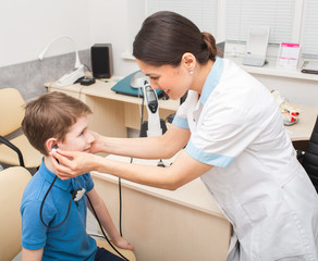 Female otolaryngologist doing a hearing test in a boy. Tympanometry measures the pressure in the middle ear. Impedance audiometry.