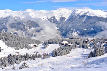 Ski resort view in winter with snowy mountains and forests