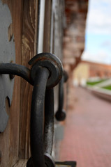forged handle of wooden historic gate close-up with perspective