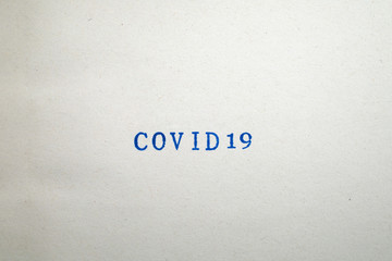 a COVID19 word stamped on a piece of paper.