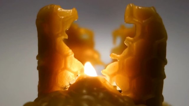 Burning Christmas candle made of beeswax