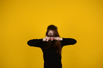 young woman in 3D glasses on a yellow background