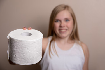 young girl holding out a roll of toilet paper