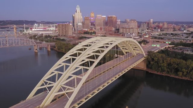 Aerial: Freeway traffic crossing the Daniel Carter Beard Bridge over the Ohio River. Cincinnati city skyline is in the distance, Ohio