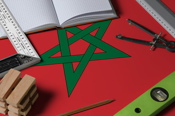 Morocco national flag on profession concept with architect desk and tools background. Top view mock-up.