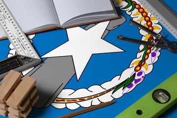 Northern Mariana Islands national flag on profession concept with architect desk and tools background. Top view mock-up.