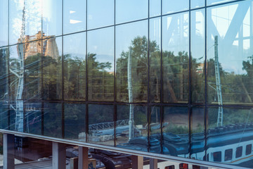 Railway station and wagons reflected in the glass structure of the waiting room