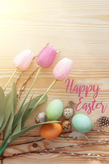 Easter eggs and tulips on a wooden table. Morning light.