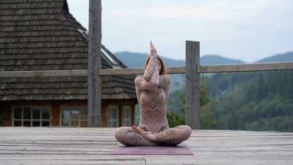 A woman sitting in lotus position at the morning on a fresh air.