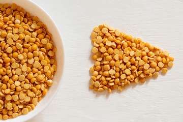 Yellow split peas in a bowl on a white background. Dry cereal for cooking.