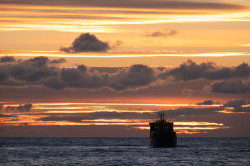 Obraz premium cargo ship at sunset. Black sea