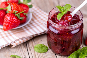 Homemade delicious strawberry jam and strawberry on a rustic wooden table