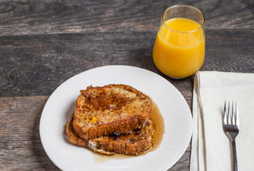 French toast with syrup and a glass of orange juice breakfast