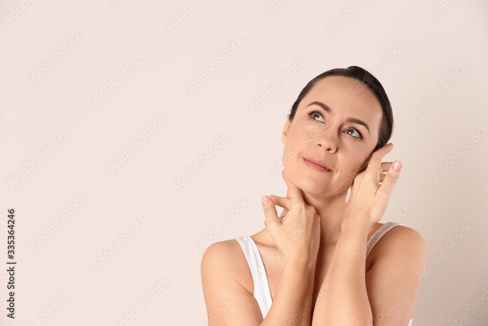 Poster Portrait of beautiful mature woman on beige background. Space for text