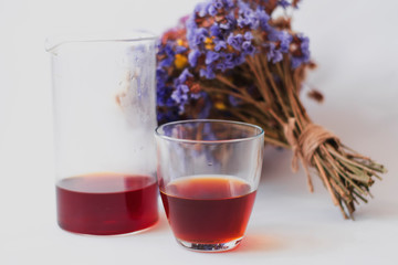 White background, strong, morning, specialty coffee brewed by an alternative method from gadget. Bouquet of field flowers and glassware.