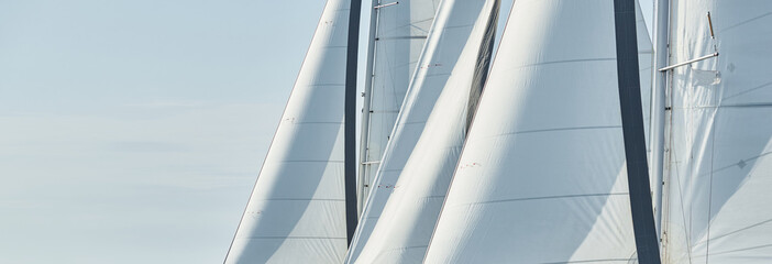 Some sails of white color, sailboats compete in a sailing regatta at sunset, sailing race