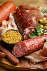Different types of sausages served on wooden board, closeup