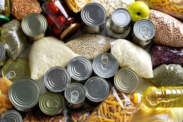 Set of raw cereals, grains, pasta and canned food on the table. - obrazy, fototapety, plakaty