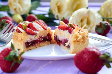 Сut of mini tart cupcake with strawberries on plate. Close up.