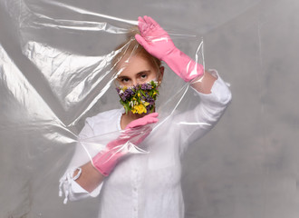 Quarantined woman wears a protective mask of flowers.
Quarantined woman breakthrough of oilcloth.