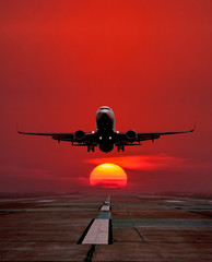 Passenger aircraft take off from airport runway against the backdrop picturesque sunrise